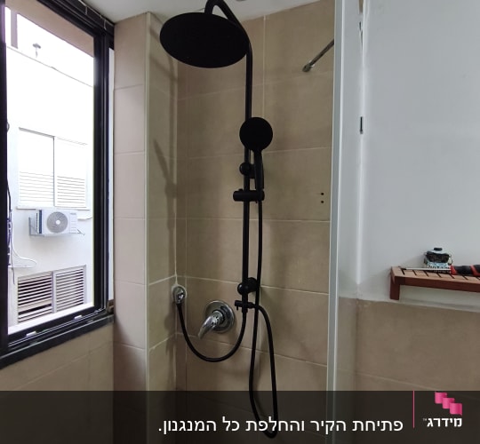 מקלחת עם ראש מקלחת שחור על קיר אריחים